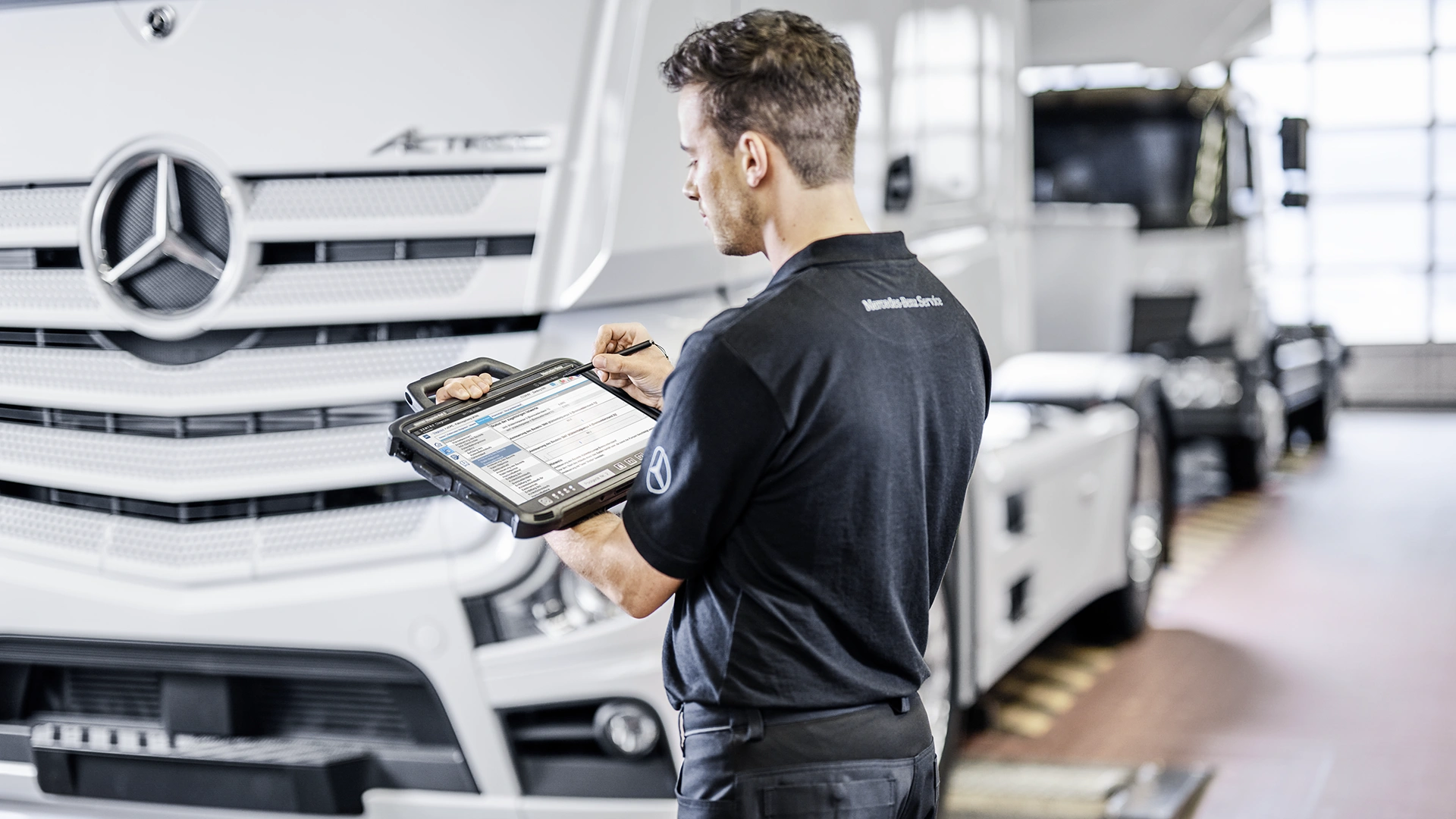 Mercedes-Benz mekaanikko tekee tarkastusta kuorma-autoon digitaalisesti