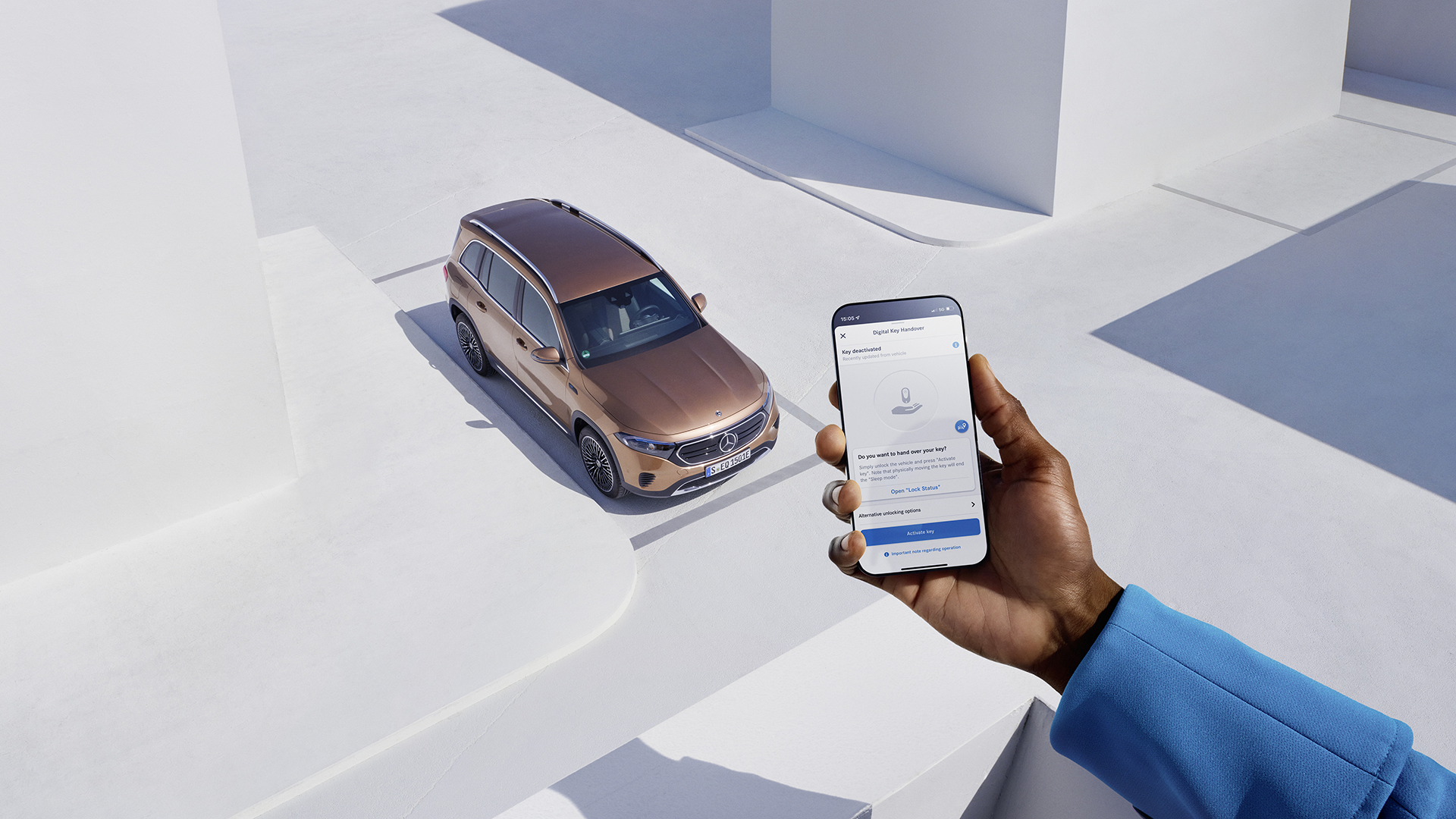 Kädessä puhelin, jossa auki Mercedes me-sovellus. Taustalla Mercedes-Benz EQB.