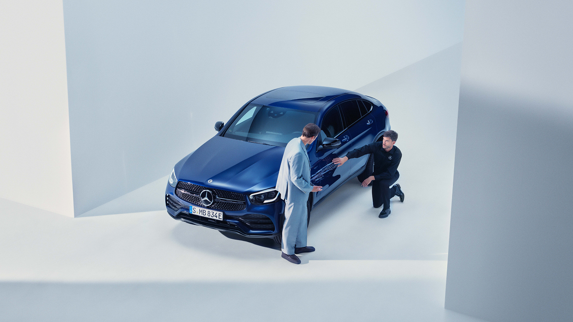 Korjaamon työnjohtaja ja asiakas arvioimassa sinisen Mercedeksen kyljen naarmuja.