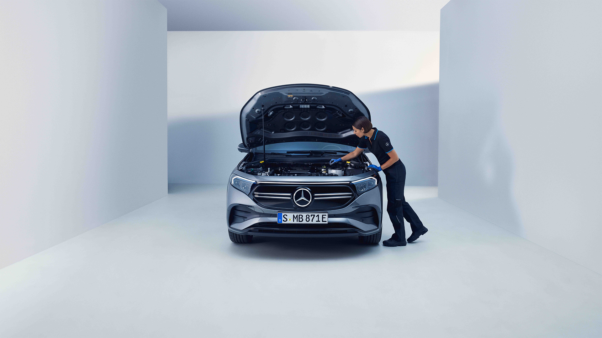 Mercedes-Benz konepelti auki ja mekaanikko työskentelemässä auton parissa.